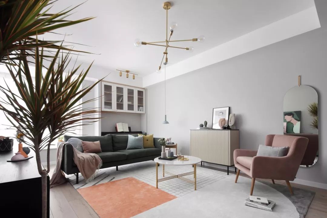 3客厅的墙面被刷成了浅灰色，小编很喜欢客厅内的软装搭配，大理石与金属结合的茶几、粉色的单椅和墨绿色的沙发，典雅又舒适。.jpg